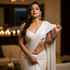 Woman in a white saree with a blurred background