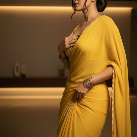 Cosmic Pearl After Dark Saree close-up – amber yellow royal crepe fabric with glistening pearl detail