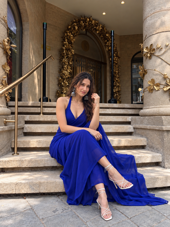 Eclipse Allure After Dark Saree — seated on stone steps in royal blue with halter blouse