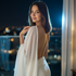 Woman in a white dress standing on a balcony with a cityscape at night.