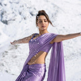Woman in a purple saree standing in a snowy landscape