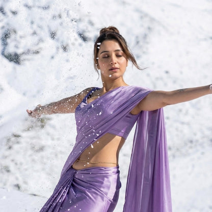 Woman in a purple saree standing in a snowy landscape