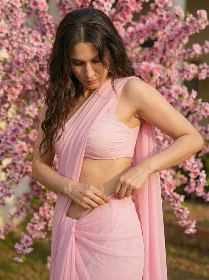 Woman adjusting the Cherry Bloom Chiffon Saree – baby pink sheer chiffon drape detail