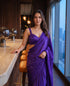 Woman standing in the Orchid Noir purple chiffon saree at a lounge bar