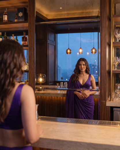 Woman looking into a bar mirror wearing the Orchid Noir purple chiffon saree