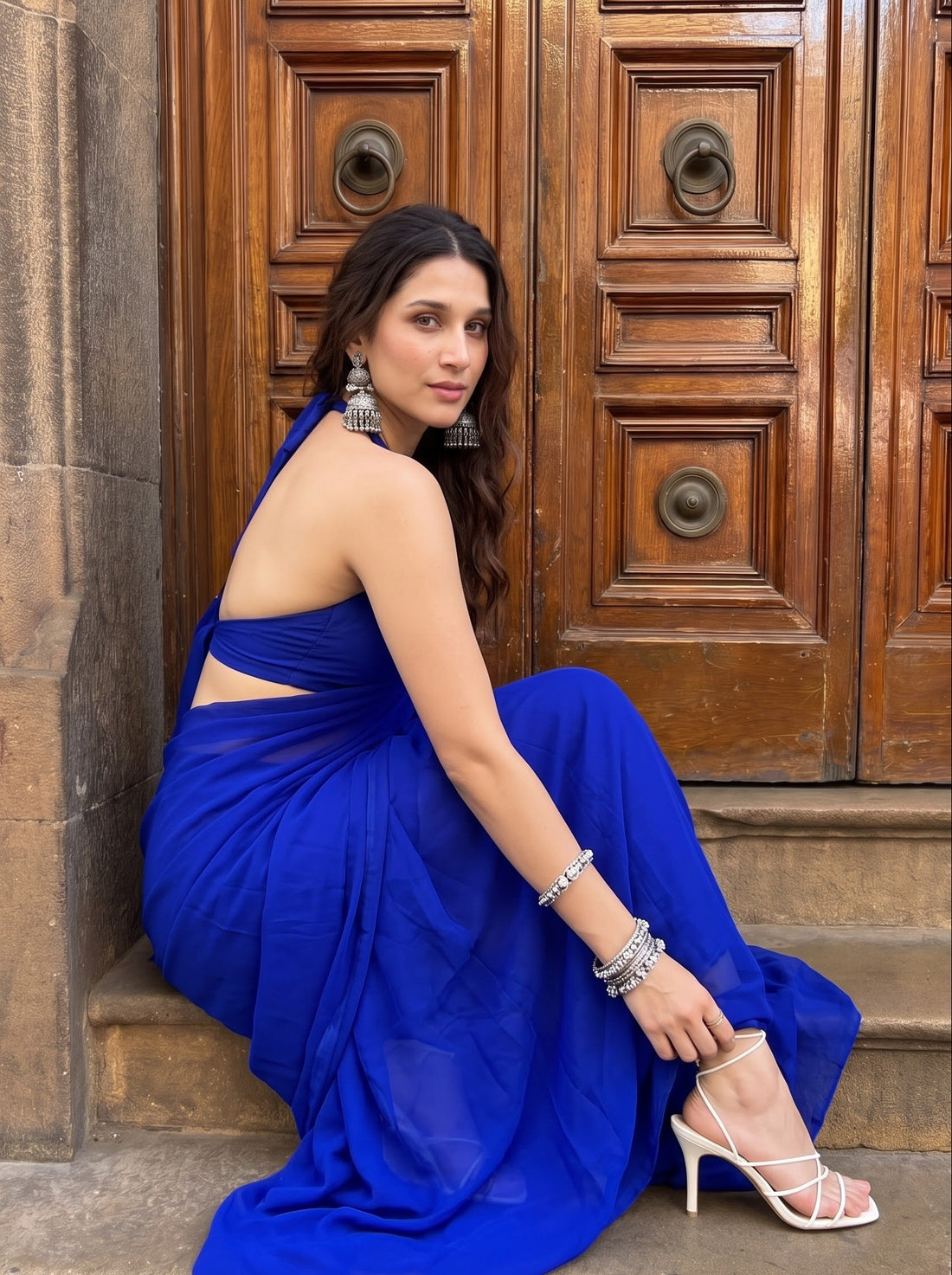 Woman posing on stone steps in the Eclipse Allure After Dark Saree