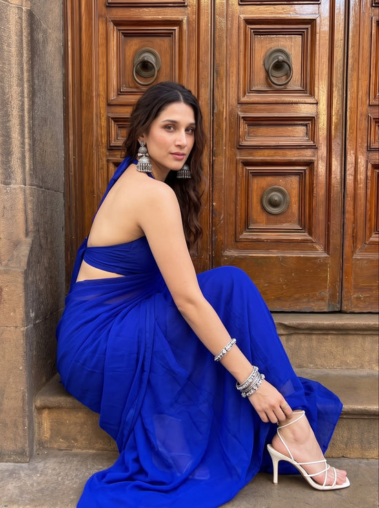 Woman posing on stone steps in the Eclipse Allure After Dark Saree