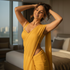 Woman in a yellow dress standing in a bedroom